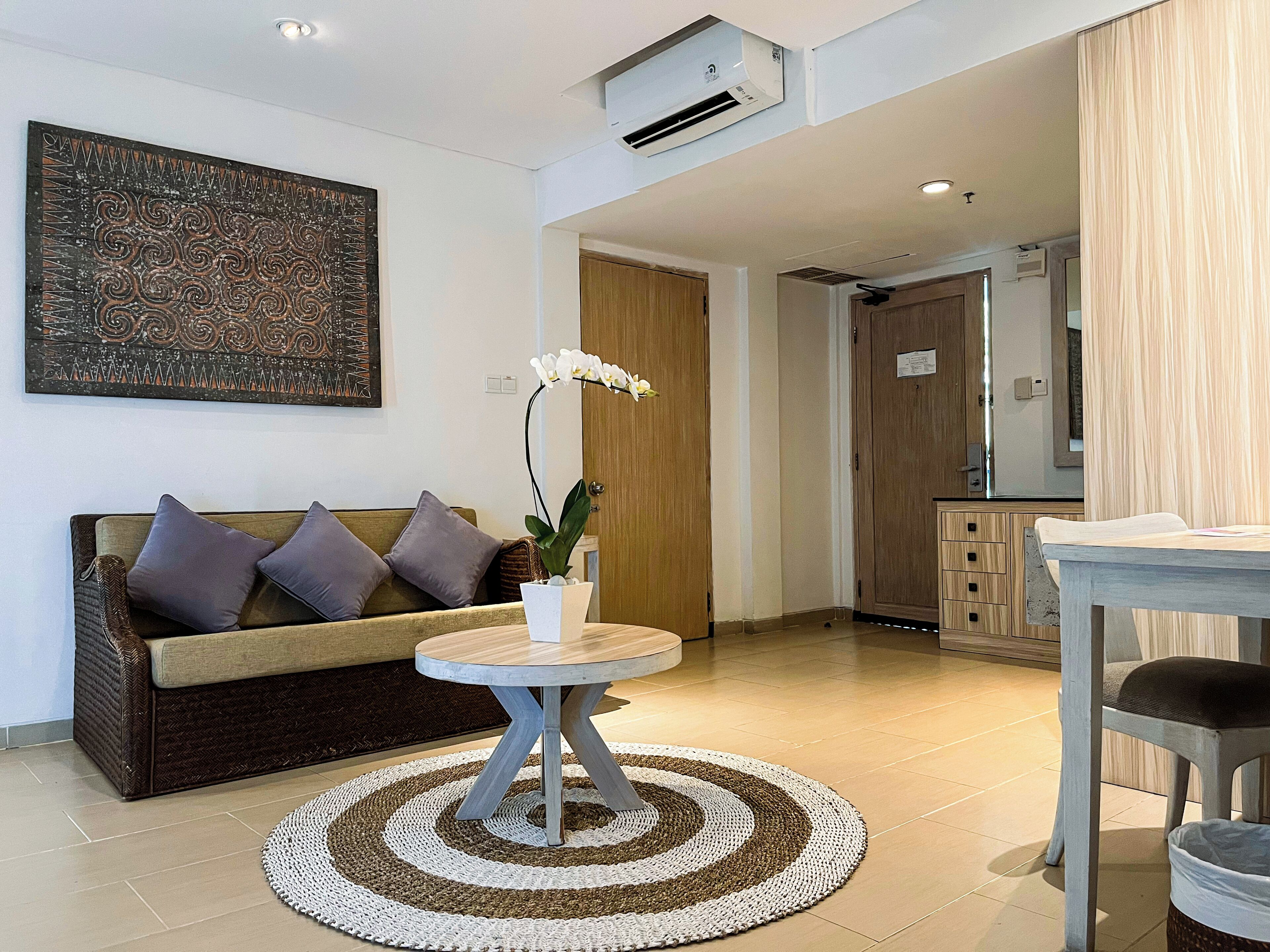 Un salon moderne avec un canapé, une table basse et un tapis décoratif.