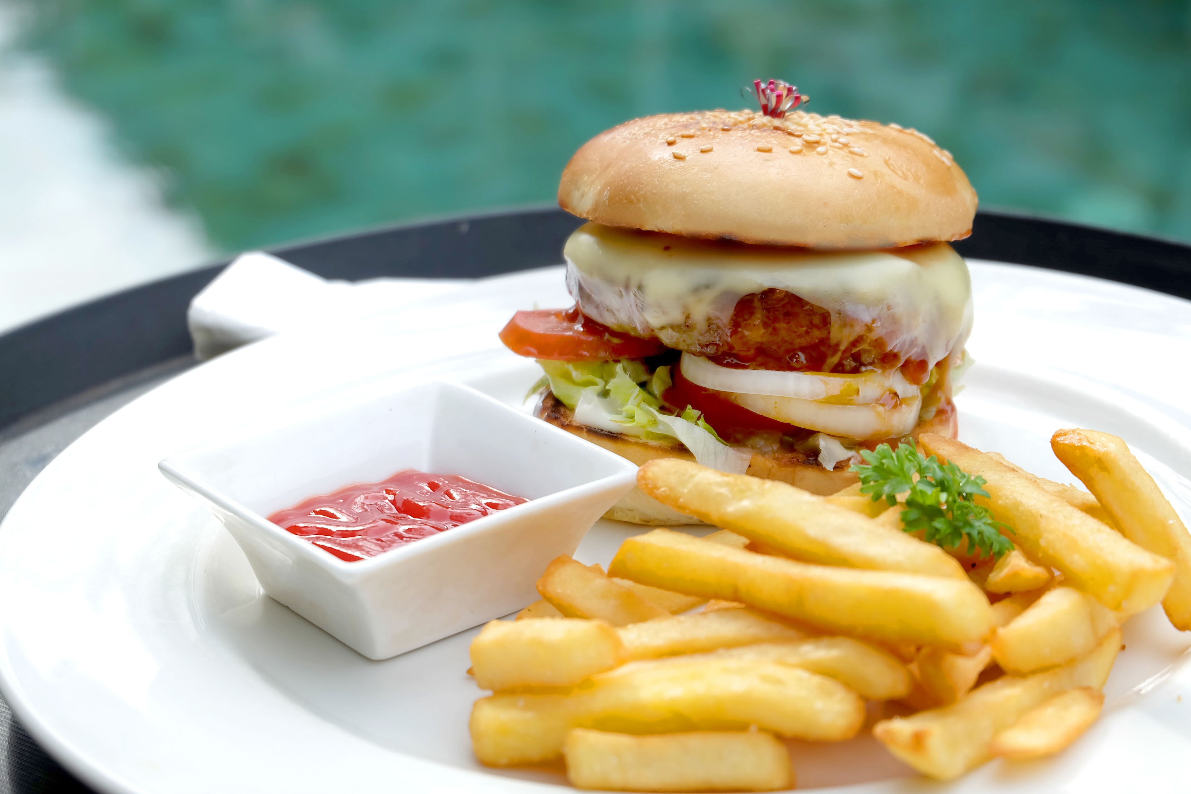 Ein Teller mit einem Burger, Pommes und Ketchup.