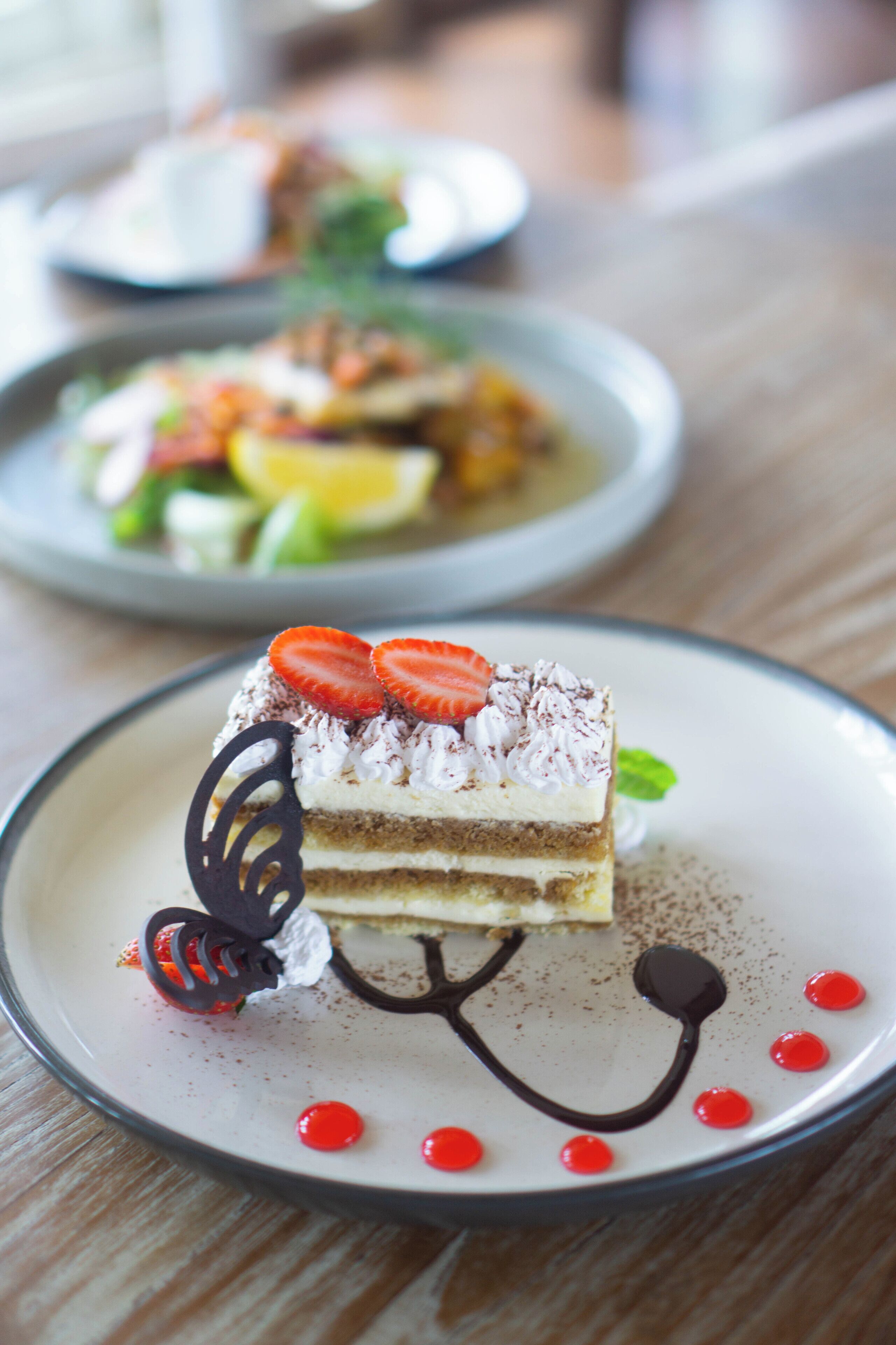 Un postre con fresas y chocolate en un plato.