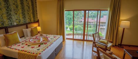 Habitación de hotel con cama, una silla, una mesa y vistas al exterior.