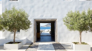 Un edificio blanco con un acceso que da a vista al mar.