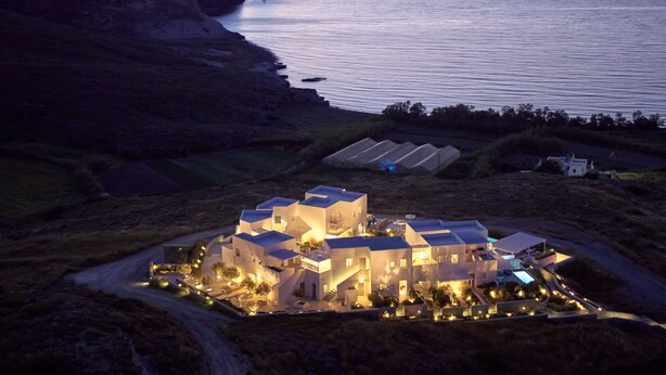 Una propiedad costera con varias construcciones, una piscina y vistas al mar y acantilados.