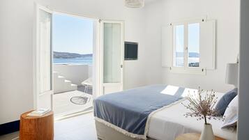Une chambre à coucher avec un lit, une fenêtre donnant sur un beau paysage et une porte menant à un balcon.