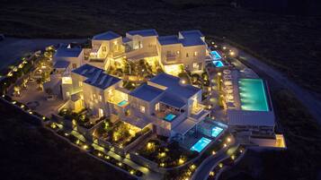 An aerial view of a resort with multiple buildings, swimming pools, and landscaped areas.