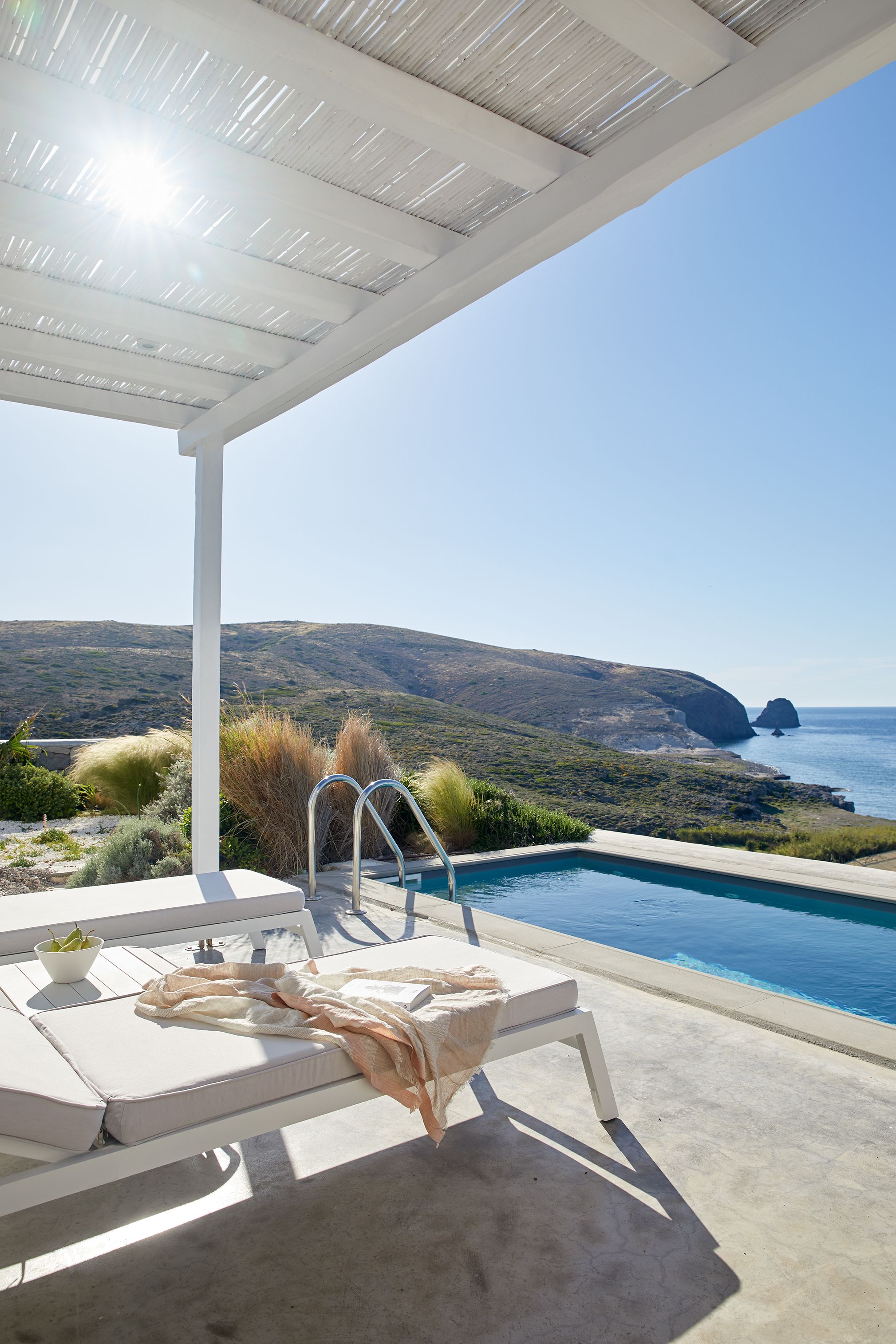 Zona de piscina amb vista al mar i a les muntanyes.
