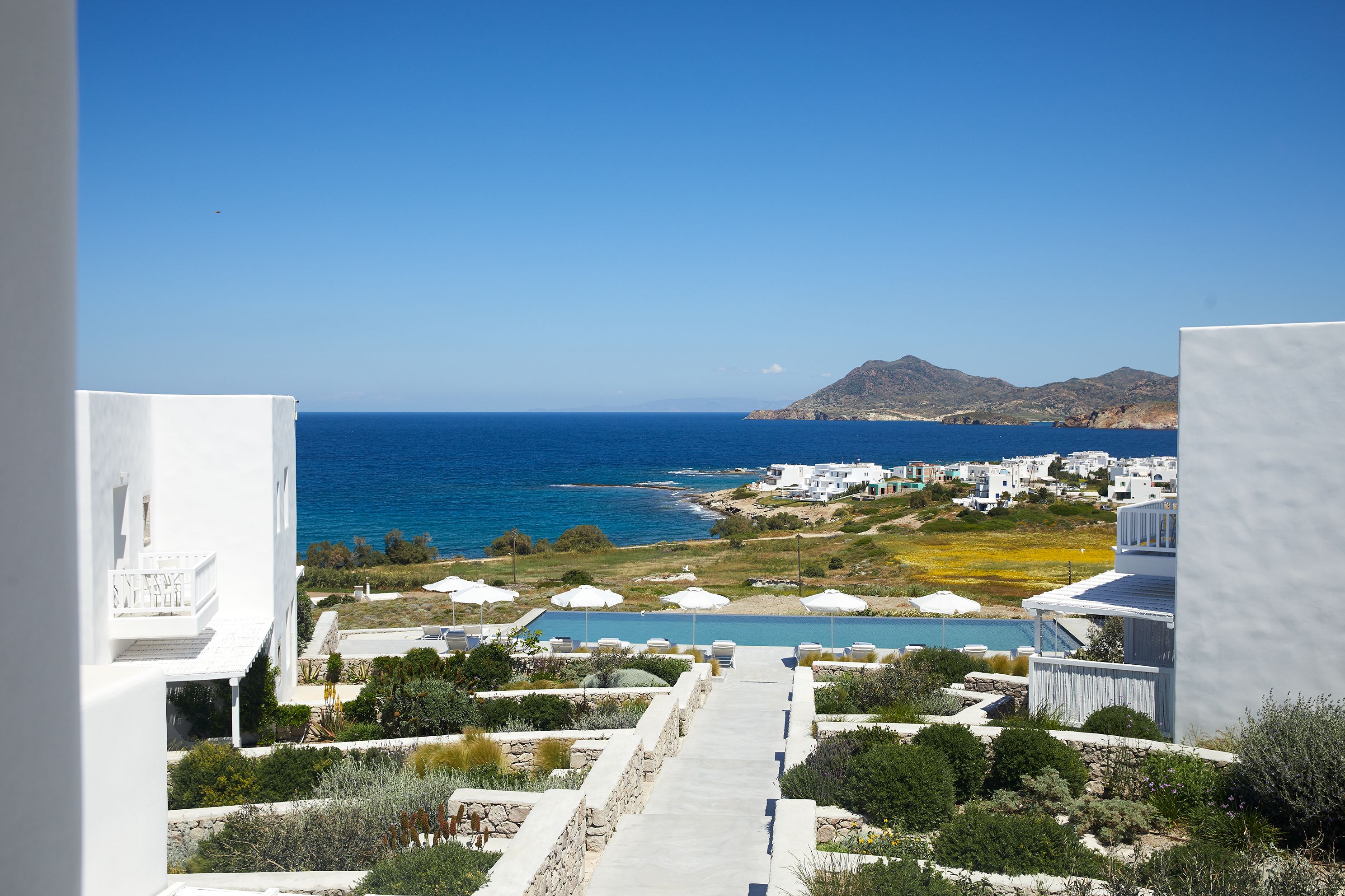 Vista costera con cielo despejado, piscina y edificios blancos.