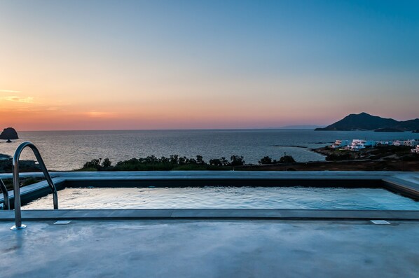 Una piscina con vistas al mar y montañas a lo lejos.