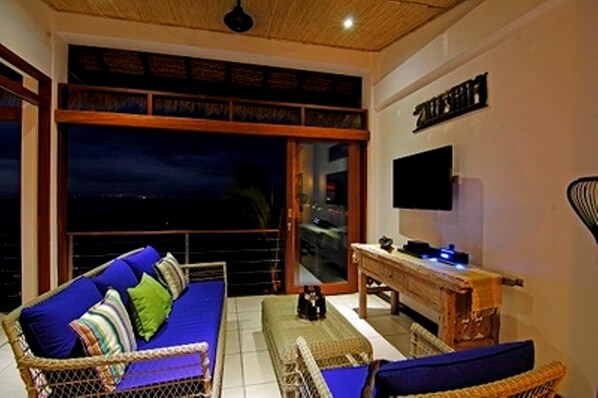 A room with a sofa, a table, and a TV. - Lembongan Sanctuary Villas (Lembongan Island)