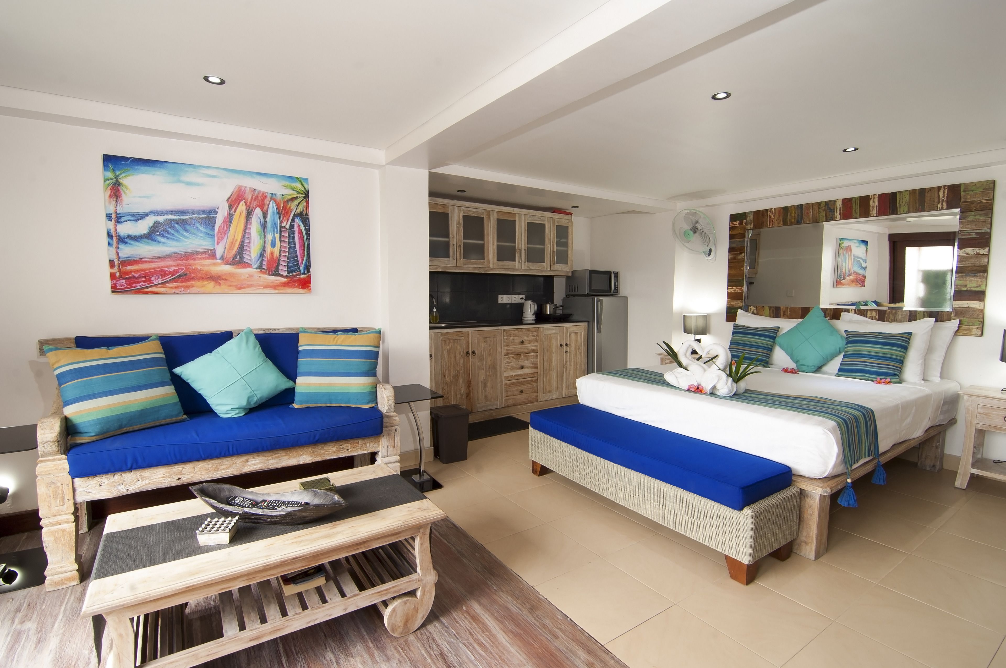 A bedroom with a bed, a sofa, and a dining table.