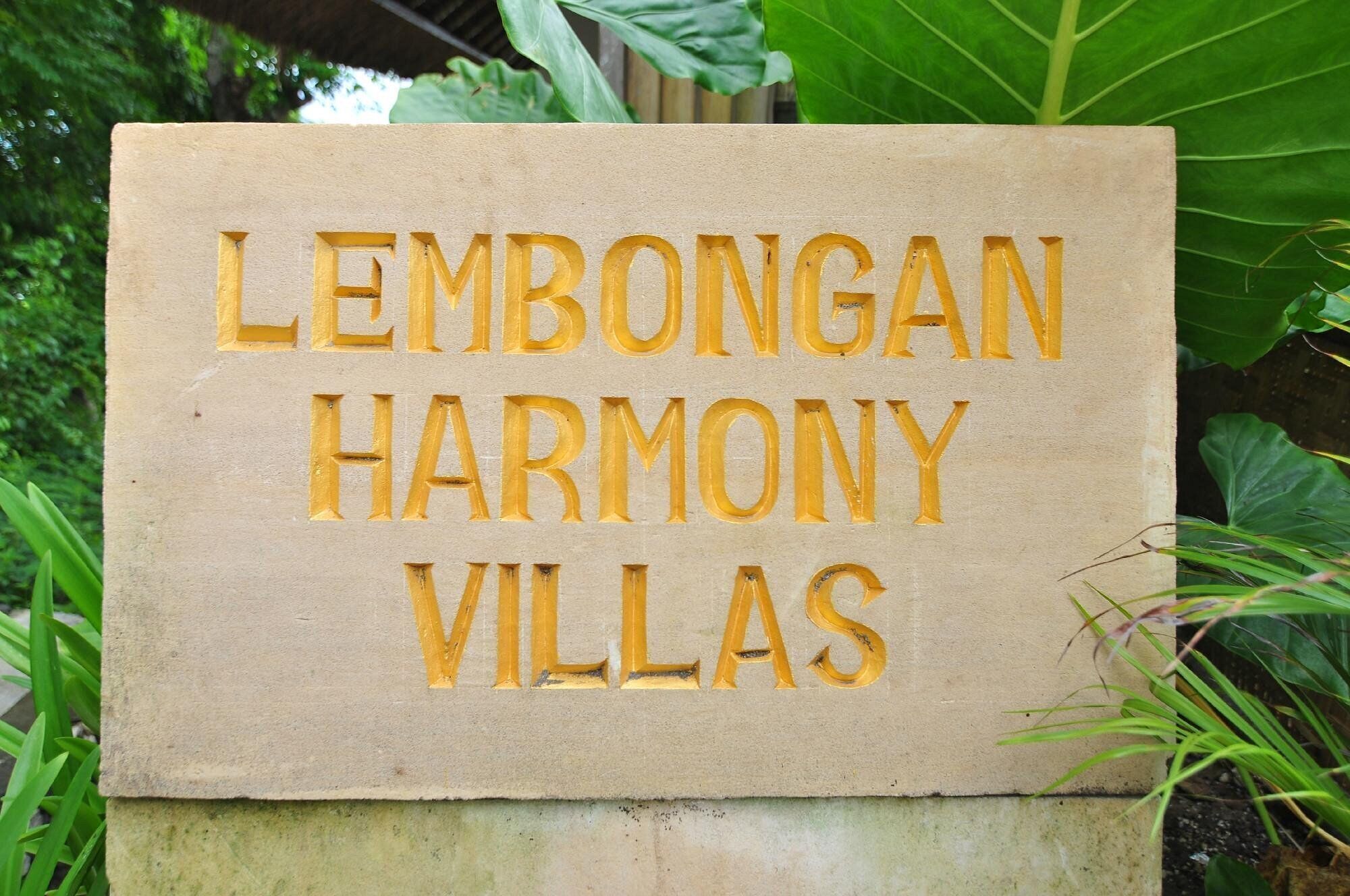 Un letrero con el texto 'LEMBONGAN HARMONY VILLAS' en letras en relieve.