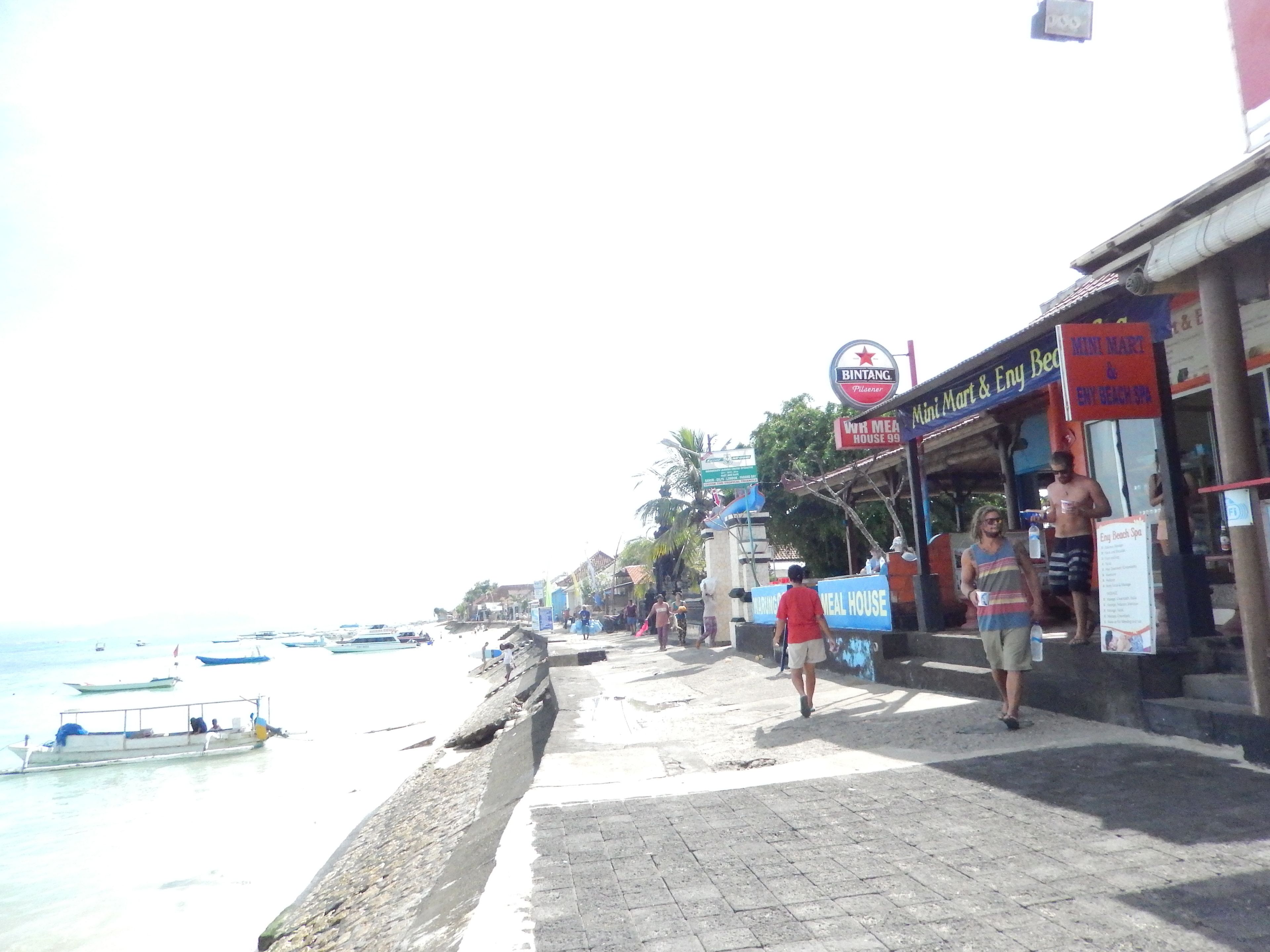 A beachfront area with a paved walkway, a sign for 'Bintang Plazer', and a 'Mini Mart & Envy Bed & Spa'.