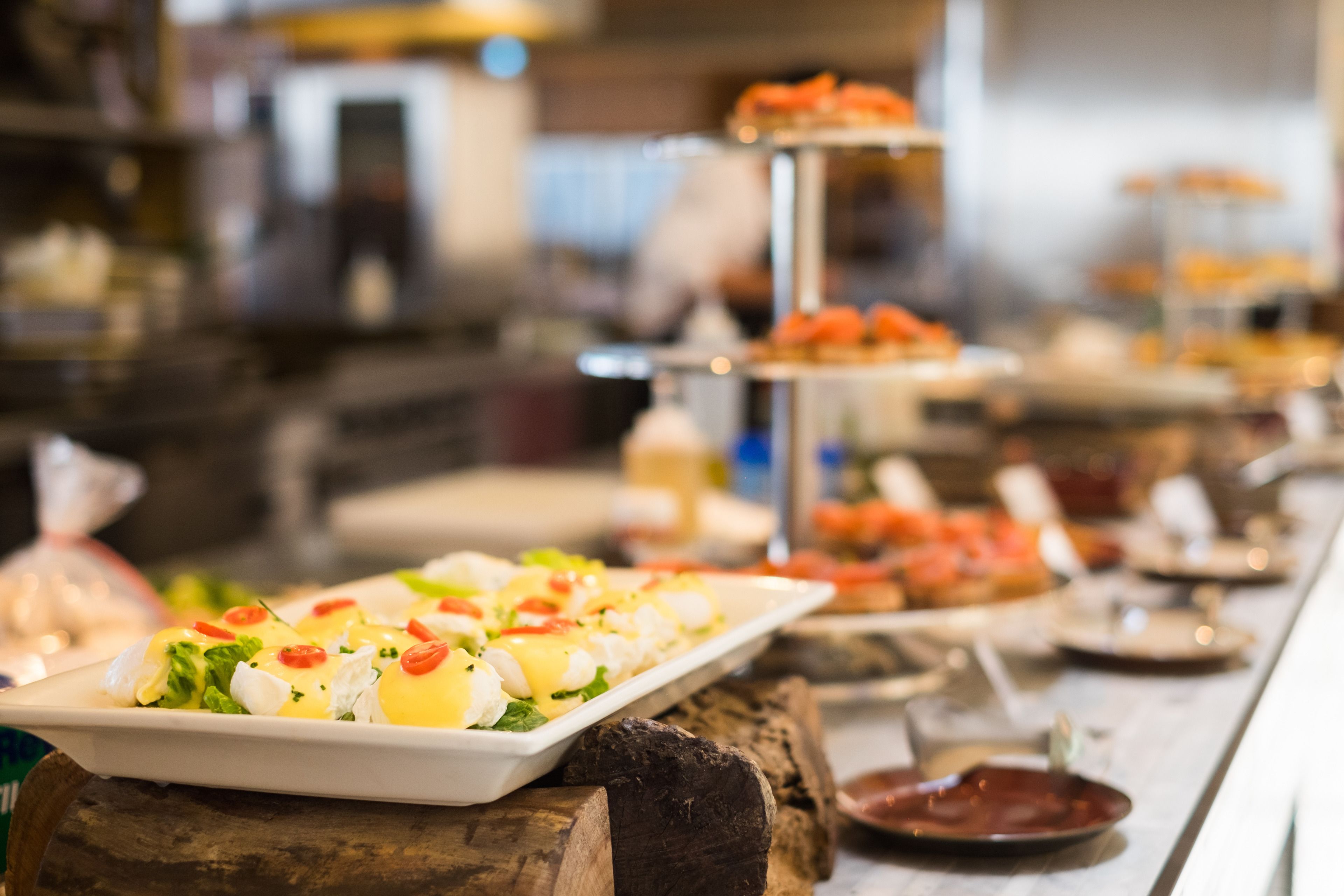 En buffet med forskellige retter, herunder et udvalg af fisk og skaldyr samt en dessertstation.