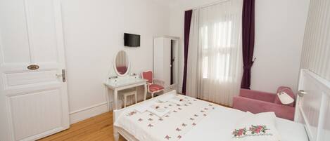 Un dormitorio con cama, tocador con espejo, silla y armario.