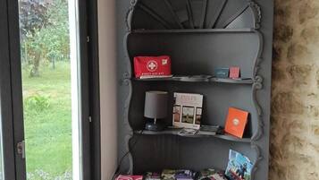 Een plank met een verbanddoos, een doos met de tekst 'PULPE' en enkele boeken.