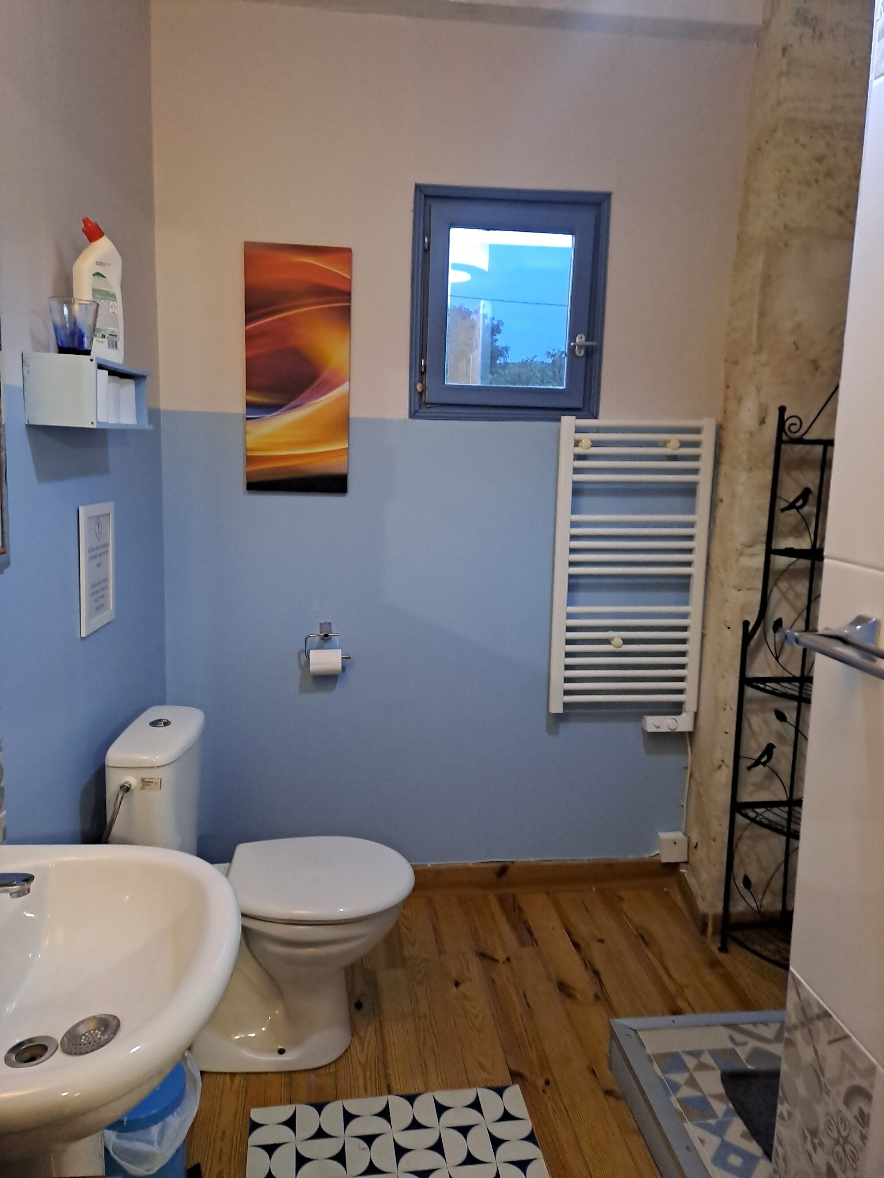 Un baño con inodoro, lavabo y ventana.