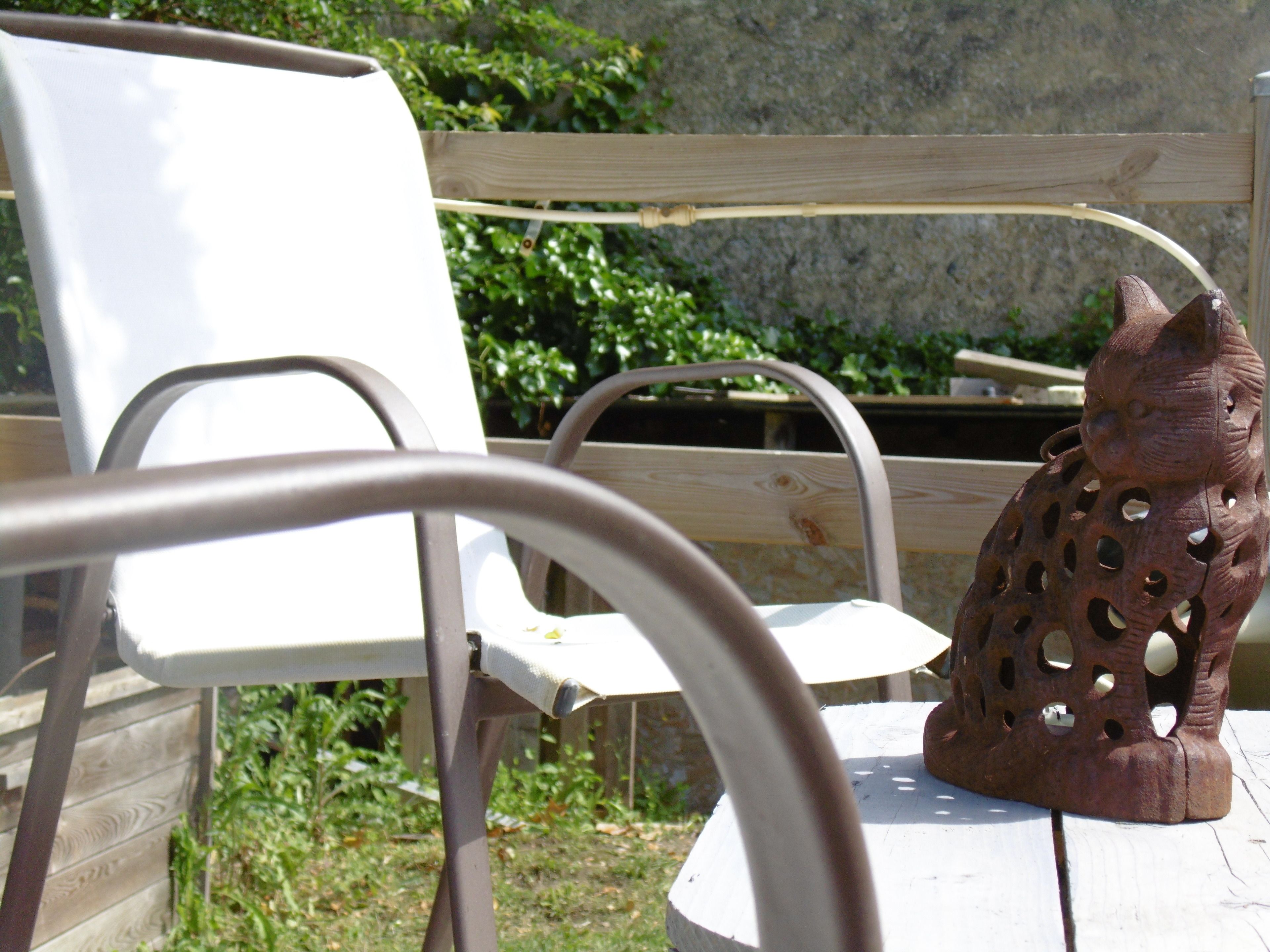 A rustic outdoor seating area with a wooden table and metal chairs.