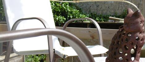 A rustic outdoor seating area with a wooden table and metal chairs.