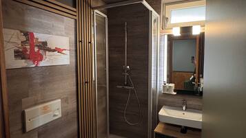 Un baño moderno con ducha, inodoro y lavamanos.