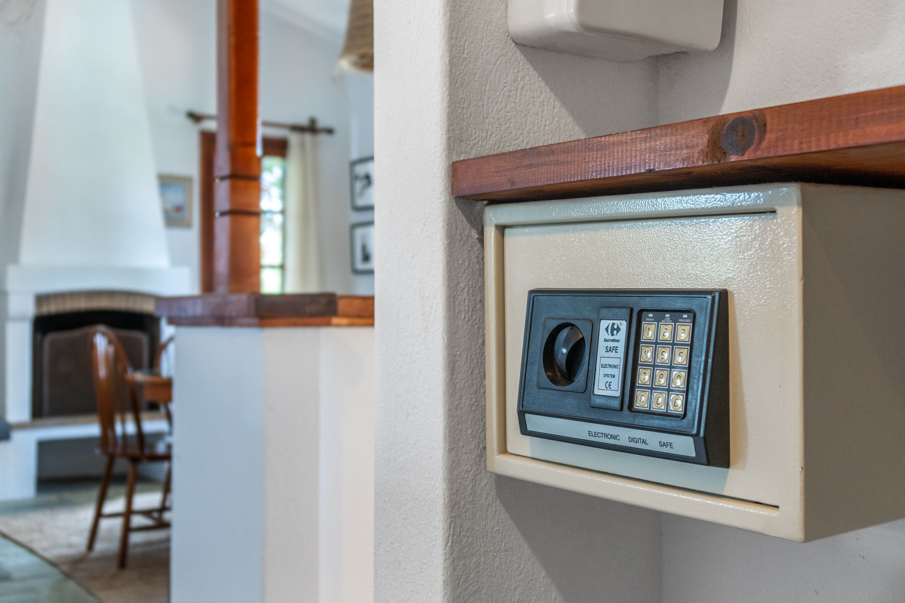 A wall-mounted electronic safe with a keypad and a dial lock.