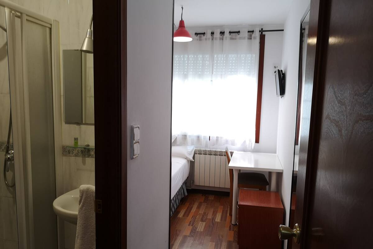Un baño con lavamanos, espejo y toalla.