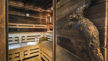 Ein Saunaraum mit Holzbänken und einer dekorativen Baumskulptur.