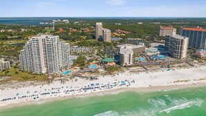 A coastal resort area with high-rise hotels, a sandy beach, and a marina.