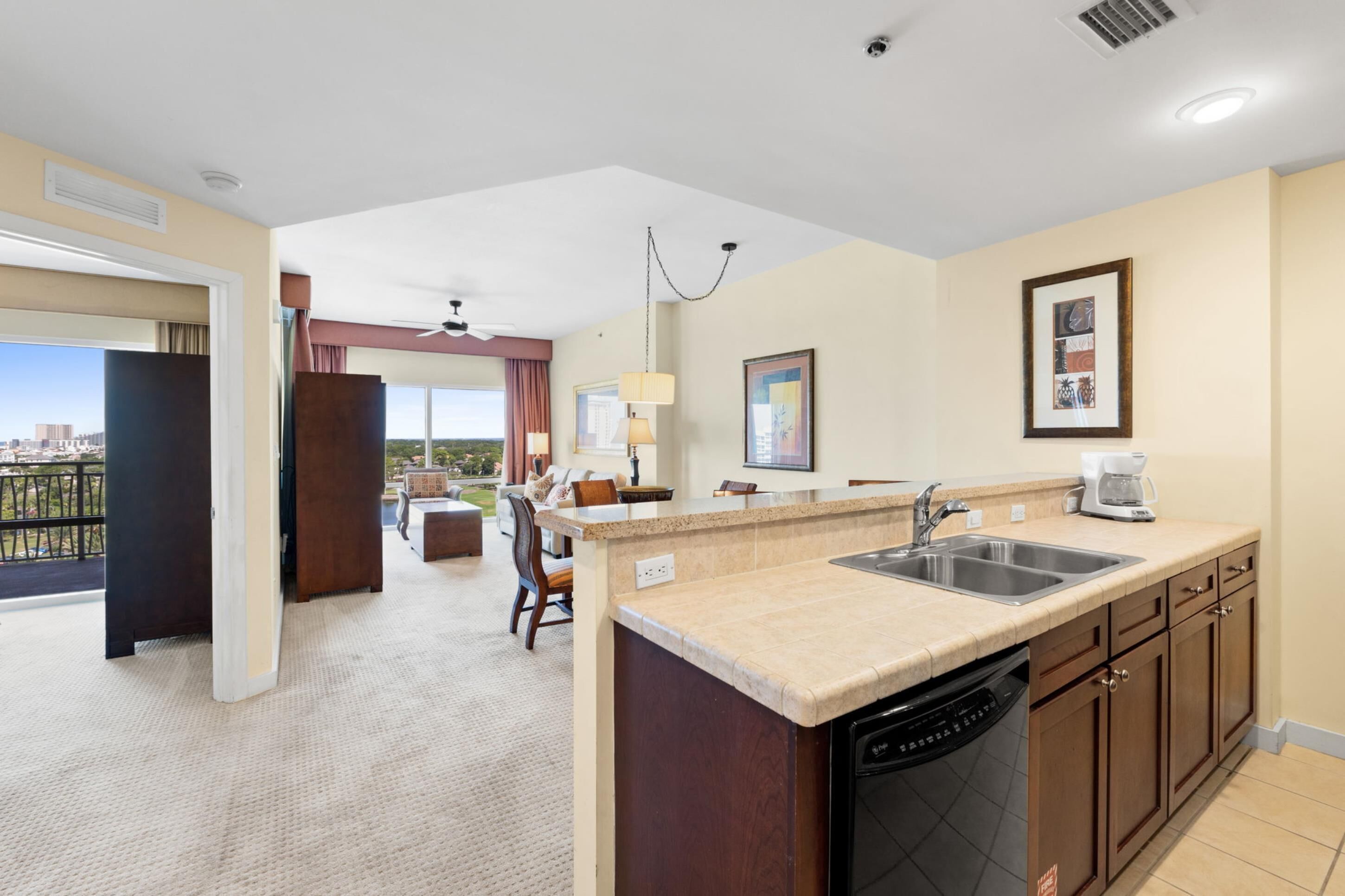 A hotel room with a kitchen area, a dining area with a view, and a balcony.
