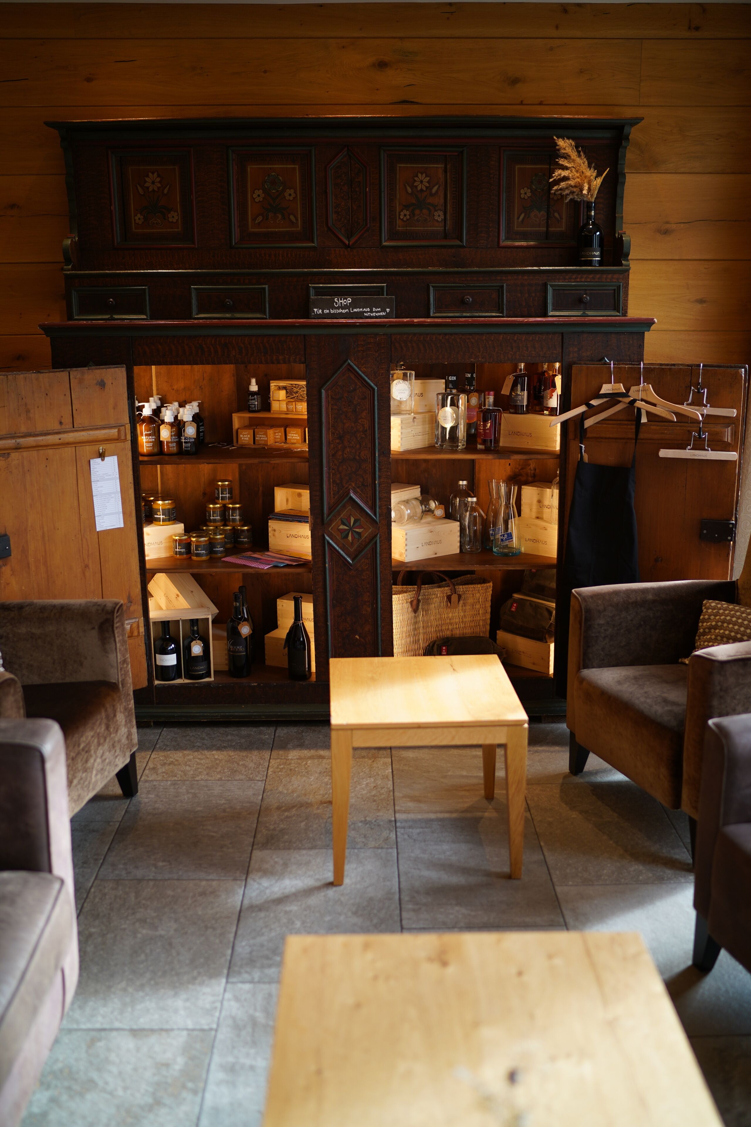 Un intérieur chaleureux, avec des meubles en bois, une table centrale et des étagères remplies de divers objets.
