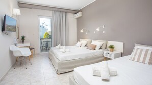 Une chambre d’hôtel avec deux lits, un bureau, une chaise et un téléviseur.