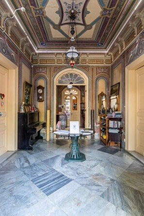 A grand hallway with marble flooring, ornate ceiling, and classical architecture. - Büyükada Anastasia Meziki History Mansion (Adalar)