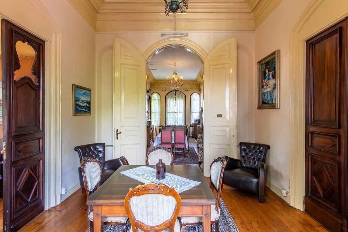 Une salle à manger élégante, avec une grande table, des chaises et un lustre.