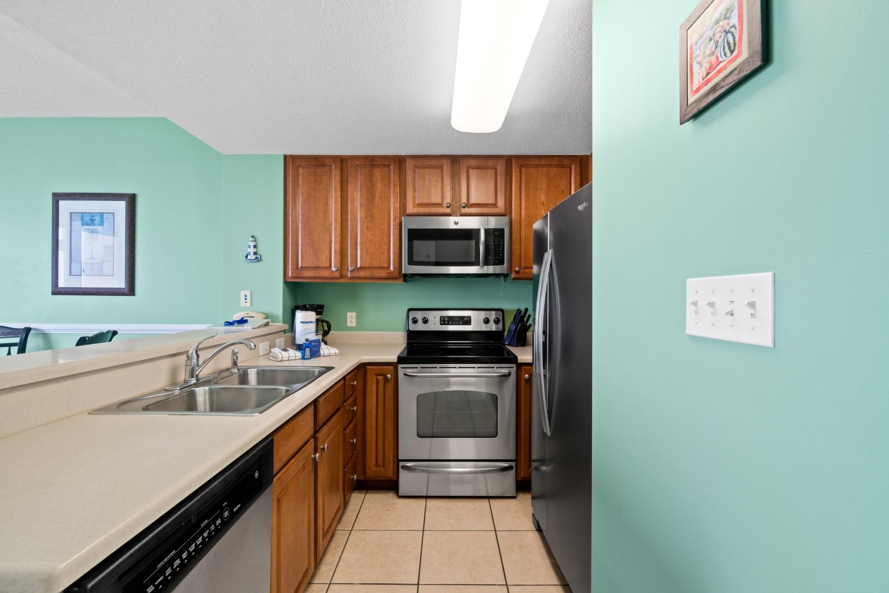 A kitchen with wooden cabinets, stainless steel appliances, a dishwasher, and a microwave.
