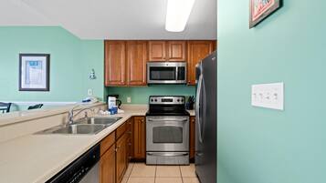 A kitchen with wooden cabinets, stainless steel appliances, a dishwasher, and a microwave.