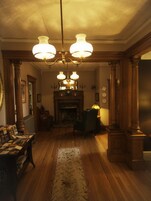 Una stanza accogliente, illuminata da luce calda, con pavimento in legno, camino e lampadario.
