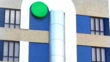 Un edificio de estilo arquitectónico moderno, con un llamativo logotipo circular verde en la fachada.