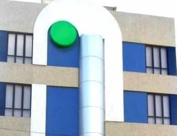 A building with a modern architectural style, featuring a prominent green circular logo on the facade. - Barra Mar Hotel (Salvador)