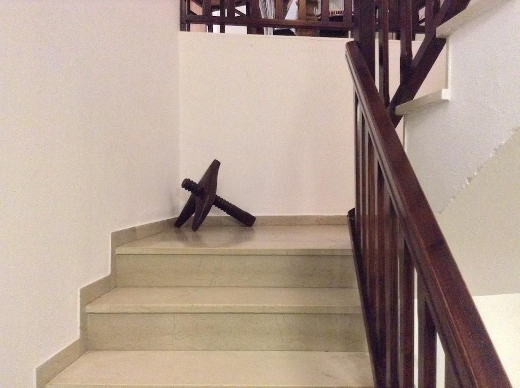 Een trap met een houten leuning en een witte muur.