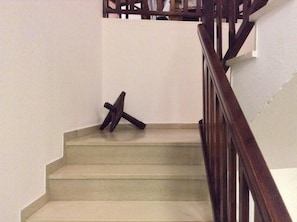 A staircase with a wooden handrail and a white wall. - Mouria (Skiathos)