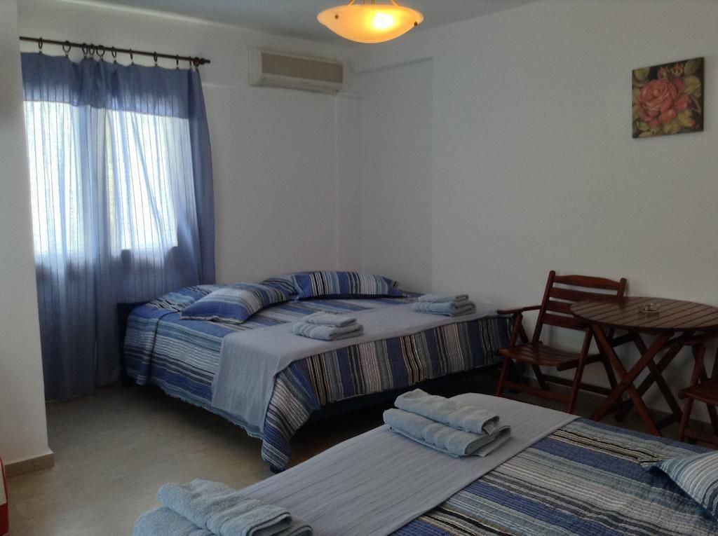 A room with two beds, a table, and a chair.