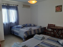Una habitación con dos camas, una mesa y una silla.