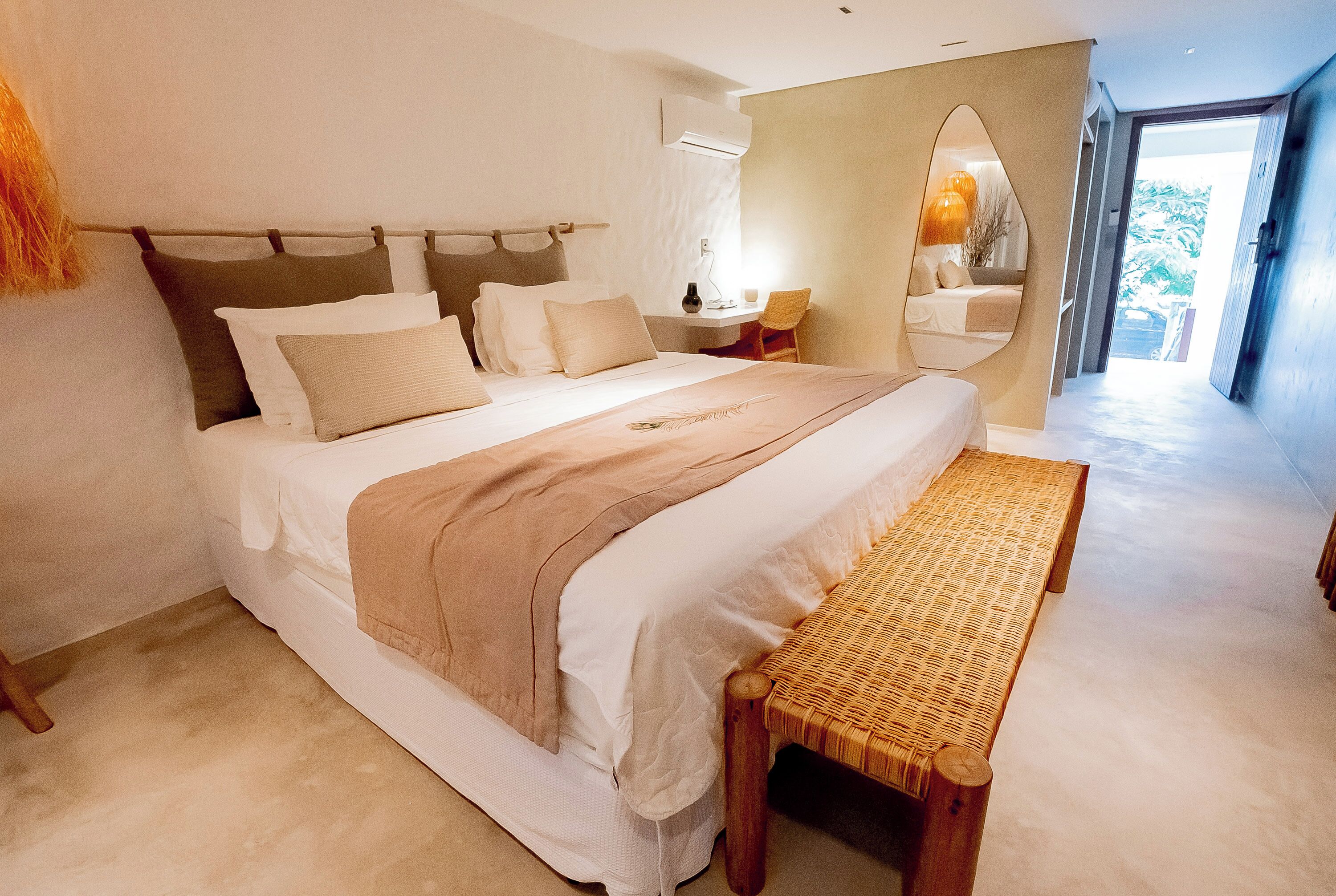 Un dormitorio moderno con una cama grande, una mesita de noche, una silla y un espejo.