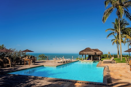 Una piscina al aire libre, sombrillas, sillones reclinables de piscina. Hotel Pontal de Ubu