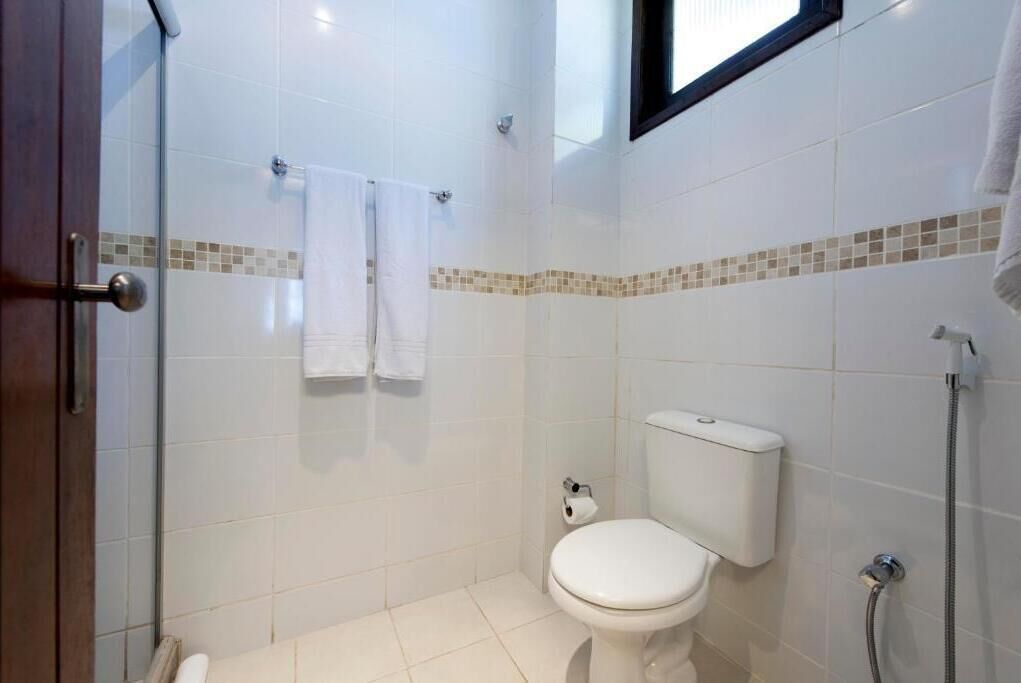 A small, clean bathroom with a toilet, a shower, and a glass door.