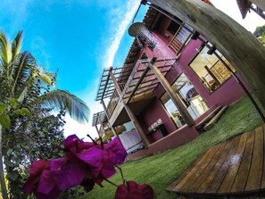 A multi-story building with a wooden deck and a water feature. - Vila Pérola Negra (Itacaré)