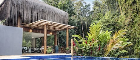 Una piscina al aire libre, sillones reclinables de piscina