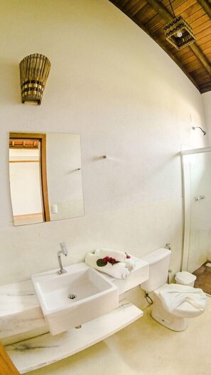 A modern bathroom with a large mirror, two sinks, a toilet, and a shower. - Vila Pérola Negra (Itacaré)