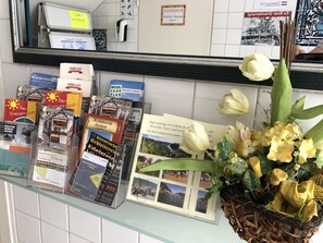 Een presentatie van reisbrochures en een decoratieve mand met bloemen.
