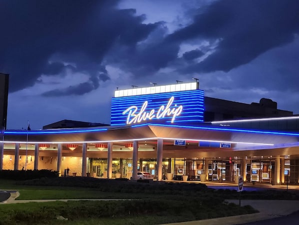 A hotel with a prominent 'Blue Chip' sign, outdoor seating area, and a parking lot. - Holiday Inn Express & Suites La Porte by IHG (La Porte)