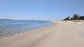 Playa en los alrededores, playa de arena blanca y sombrillas
