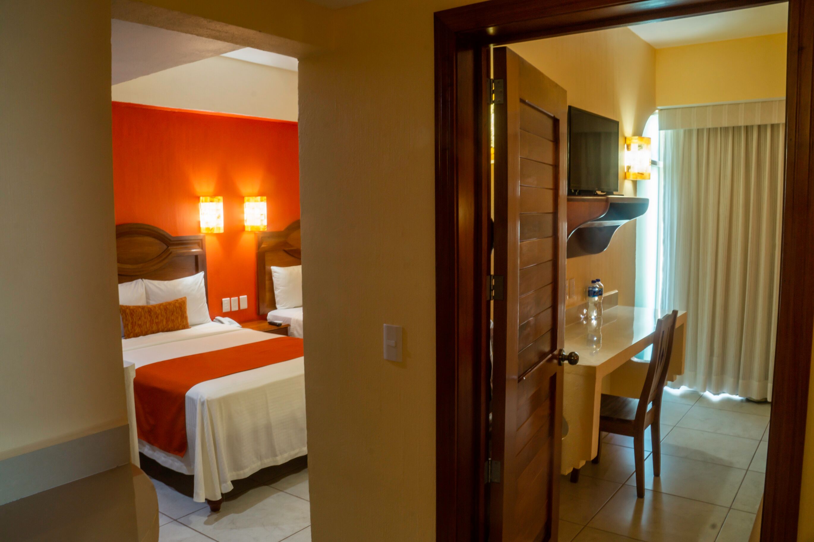 Una habitación de hotel con cama, mesita de noche y escritorio con silla.
